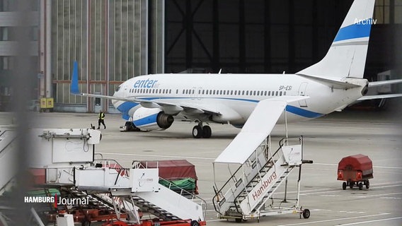 Vor einem geöffneten Hanger rollt ein Flugzeug Richtung Startbahn. © Screenshot 