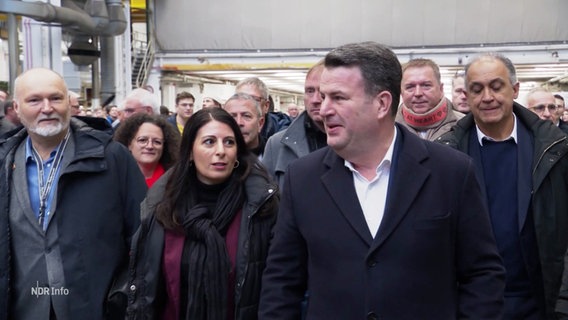 Daniela Cavallo und Arbeitsminister Hubertus Heil, hinter Ihnen laufen viele Menschen. © Screenshot 