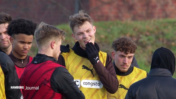 Spieler des FC St. Pauli stehend beratend bei einer Trainingseinheit beieinander. © Screenshot 