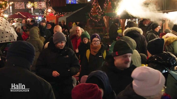 Zwischen Buden und Dekoration tummeln sich Weihnachtsmarktbesucher. © Screenshot 