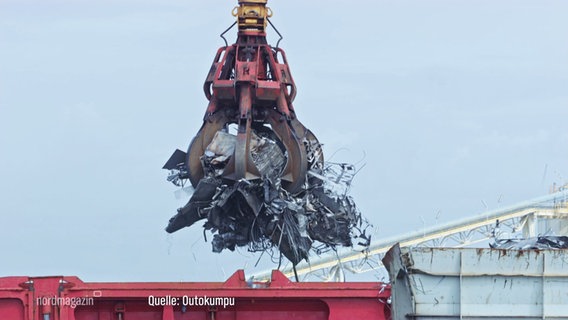 Ein Krahn hebt Stahlschrott aus einem Container. © Screenshot 