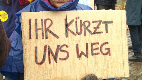 Ein Plakat mit der Aufschrift "Ihr kürzt uns weg". © Screenshot 