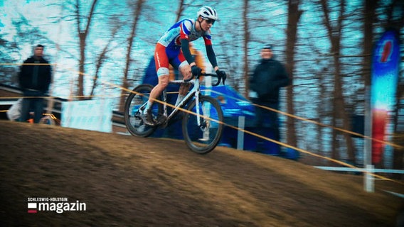 Ein Teilnehmer der Cyclocross-Nordmeisterschaften in Kiel fährt mit seinem Rad einen Berg hinunter. © Screenshot 