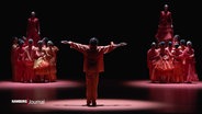 Szene aus "Slow Burn" an der Hamburgischen Staatsoper: Tänzer:innen in rot gefärbten Kostümen. © Screenshot 