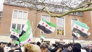 Jubelnde Demonstrierende schwenken syrische Flaggen. © Screenshot 