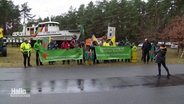 Protestierende der Umweltinitiative stehen an der Straße. © Screenshot 