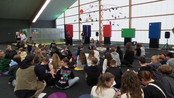 Schüler sitzen auf dem Boden beim Berufswahlparcours in Stralsund. © Screenshot 