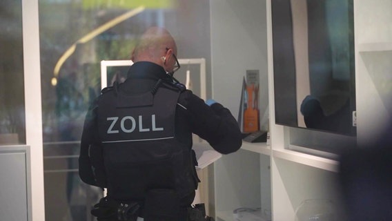 Ein Zollbeamter bei der Razzia des Marklerunternehmens Engel & Völkers. © Screenshot 