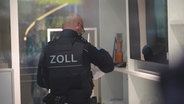 Ein Zollbeamter bei der Razzia des Marklerunternehmens Engel & Völkers. © Screenshot 