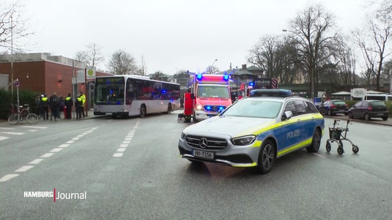 Ein Polizeiwagen, ein Krankenwagen und ein Bus stehen auf einer Straße. © Screenshot 