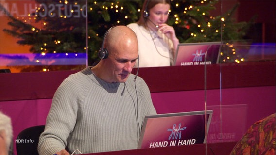 Ein Mann sitzt mit Headset vor einem Computer in einem Callcenter bei einer Fernseh-Spendengala. © Screenshot 