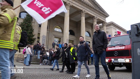 Bei einer Demonstration gehen Mitarbeitende der Feuerwehr mit ver.di-Fahnen auf die Straße. © Screenshot 