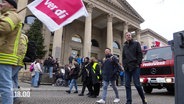 Bei einer Demonstration gehen Mitarbeitende der Feuerwehr mit ver.di-Fahnen auf die Straße. © Screenshot 