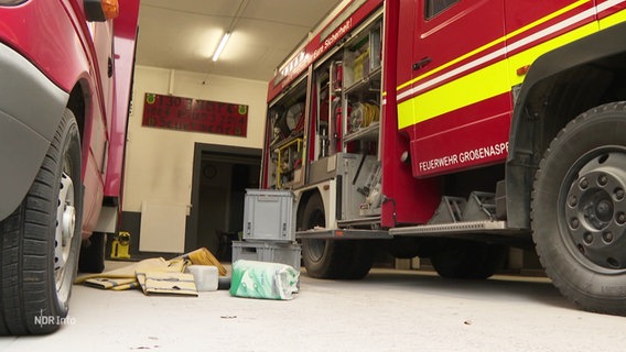 In dem Garagenraum einer Feuerwehrwache liegen Utensilien auf dem Boden verstreut. © Screenshot 