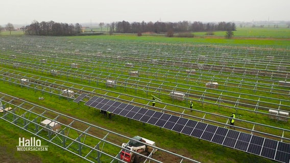 Blick aus der Vogelperspektive auf einen sich im Aufbau befindenden Solarpark auf einem Feld © Screenshot 