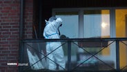 Eine Person in weißer Schutzkleidung fotografiert Spuren auf einem Balkon. © Screenshot 