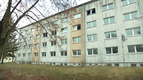 Ein Plattenbau mit teils eingeschlagenen Fenstern © Screenshot 