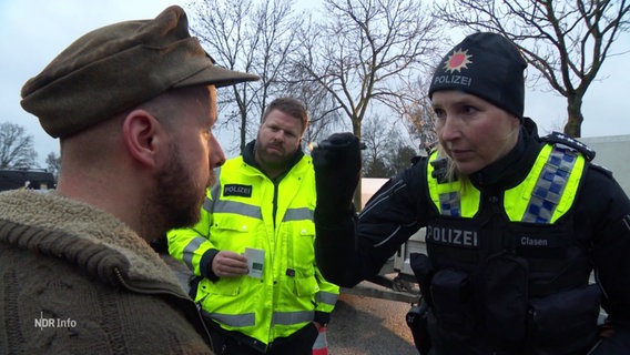 Eine Polizistin leuchtet einem Mann mit einer kleinen Lampe in die Augen. © Screenshot 