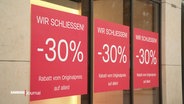 Schilder in einem Ladengeschäft mit der Aufschrift "Wir schließen! -30%". © Screenshot 