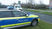 Ein parkendes Polizeiauto, im Hintergrund ein Einsatzfahrzeug mit Blaulicht. © Screenshot 