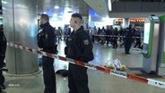 Zwei Polizisten an einer Absperrung am Hauptbahnhof Hannover. © Screenshot 