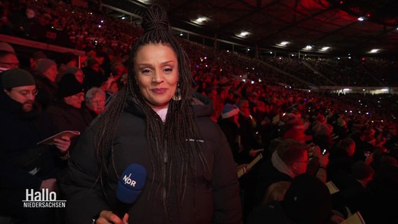 Nadja Babalola berichtet von der Tribüne beim Weihnachts-Stadionsingen. © Screenshot 