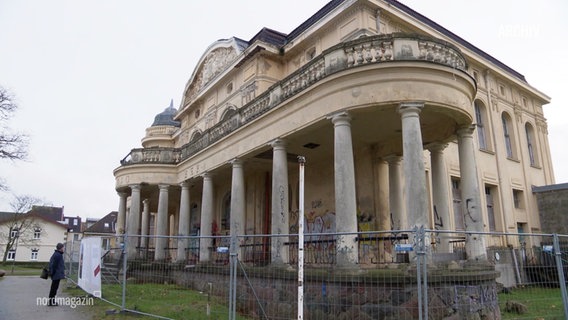 Die mit einem Bauzaun umgebene Villa Baltic. Das historische Gebäude ist in baufälligem Zustand und mit Graffiti bedeckt. © Screenshot 