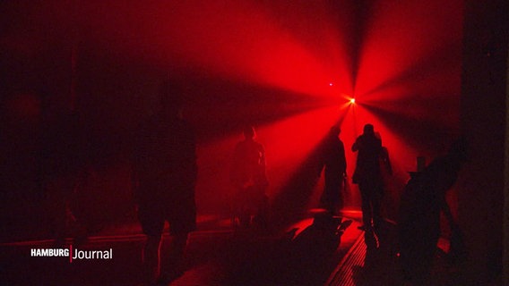 Silhouetten von Menschen im roten Gegenlicht. © Screenshot 