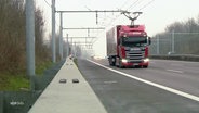 Ein Hybrid-LKW fährt über die Autobahn und nutzt dabei eine Stromtrasse. © Screenshot 