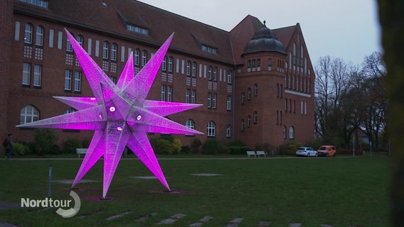 Auf einer Wiese ist ist ein größerer, lila leuchtender Stern aufgebaut. © Screenshot 