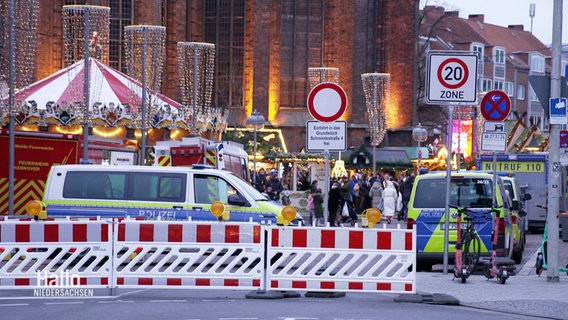 Vor dem Eingang zu einem Weihnachtsmarkt sind Baustellen-Absperrungen aufgestellt. © Screenshot 