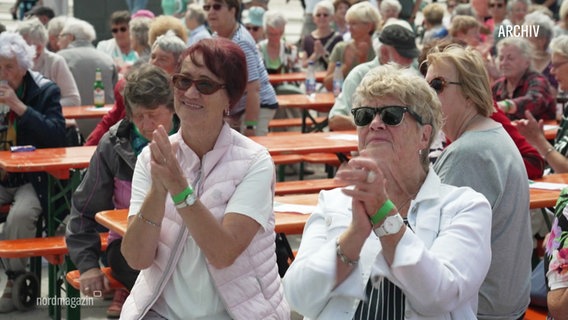 Zwei ältere Damen klatschen bei einem Open-Air-Konzert. © Screenshot 