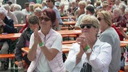 Zwei ältere Damen klatschen bei einem Open-Air-Konzert. © Screenshot 