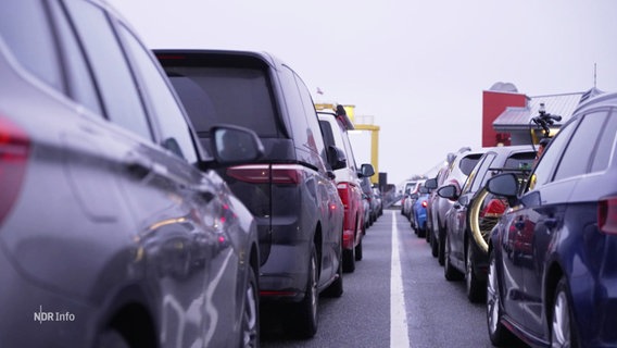 Viele Autos stehen in einer Reihe vor der Fähre. © Screenshot 