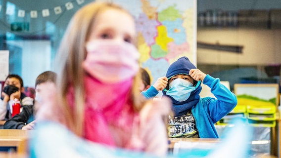 Kinder einer Schulklasse tragen medizinische Masken. © Screenshot 