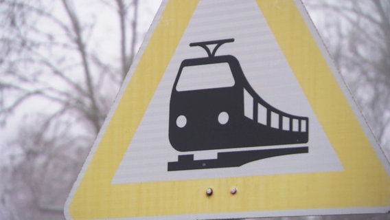 Ein straßenschild weißt auf einen Bahnübergang hin. © Screenshot 