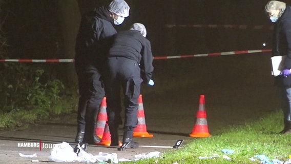 Mitarbeitende der Spurensicherung fotografieren einen abgesperrten Fußweg bei Nacht. © Screenshot 