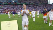 Fußballspieler Toni Kroos applaudiert auf dem Spielfeld. © Screenshot 