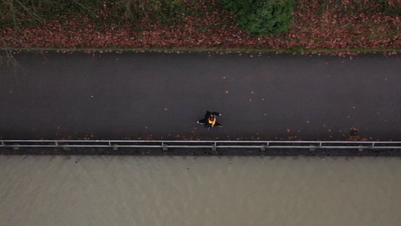 Eine Frau joggt auf einer Straße. © Screenshot 