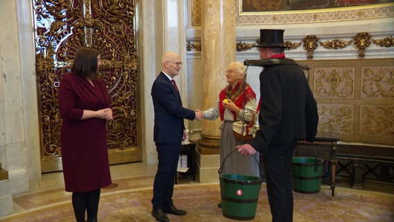 Fegebank und Tschentscher begrüßen Menschen im Rathaus. © Screenshot 