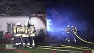 Mehrere Feuerwehrmänner löschen einen Brand. © Screenshot 