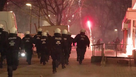 Einsatzkräfte der Hamburger Polizei laufen Silvester bei einem Einsatz im Stadtteil Steilshoop. © Screenshot 