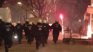 Einsatzkräfte der Hamburger Polizei laufen Silvester bei einem Einsatz im Stadtteil Steilshoop. © Screenshot 