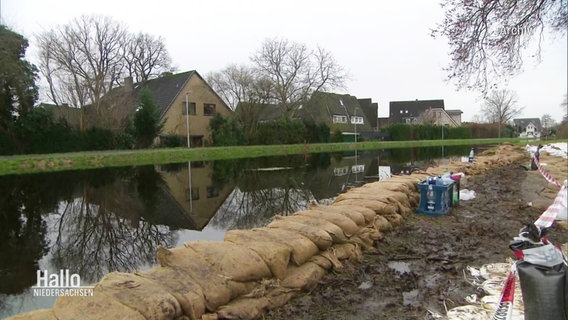 Auf einem Deich stehen Sandsäcke um das Hochwasser abzuhalten. © Screenshot 