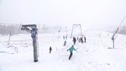 Menschen auf einem verschneiten Hang im Oberharz. © Screenshot 