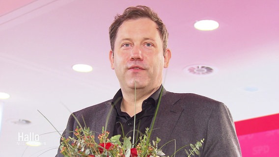 Lars Klingbeil (SPD) hält einen Blumenstrauß in der Hand. © Screenshot 