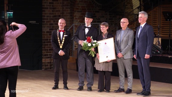 Stadtvertreter und die Preisträgerin der Wilhelm-Ahlers-Medaille posieren für ein Gruppenfoto. © Screenshot 