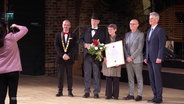 Stadtvertreter und die Preisträgerin der Wilhelm-Ahlers-Medaille posieren für ein Gruppenfoto. © Screenshot 