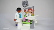 Ein Playmobil-Zahnarzt mit passendem Behandlungsstuhl und Playmobil-Patientin © Screenshot 