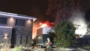 Ein Einfamilienhaus in Hamburg-Hummelsbüttel steht in Flammen. Feuerwehrleute sind im Einsatz. © NonstopNews 